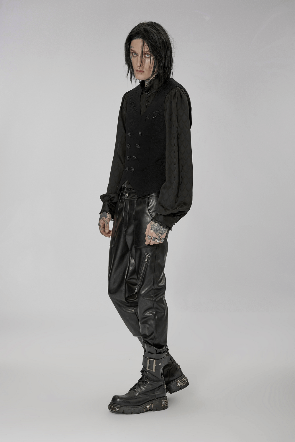 Model wearing a Victorian-inspired jacquard goth vest with black pants and boots, showcasing vintage goth elegance.