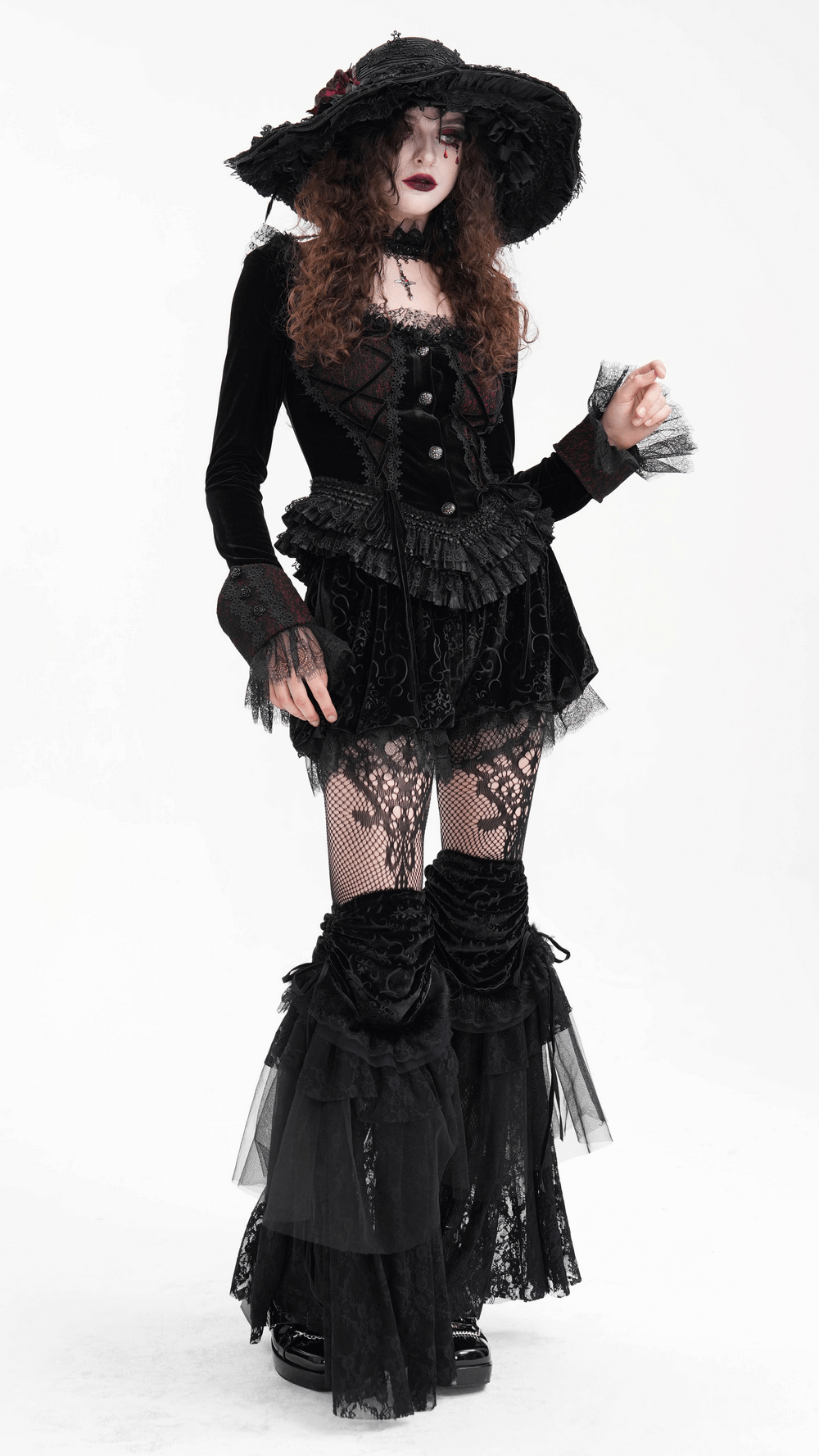 Victorian-inspired gothic model wearing layered lace and velvet leg warmers with tulle accents and a stylish black hat.