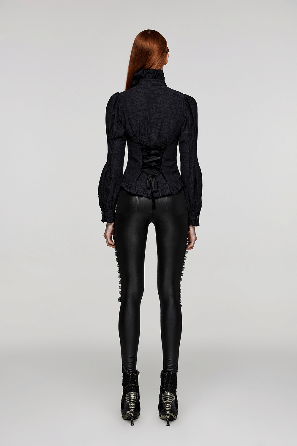 Back view of a Victorian-inspired goth blouse with ruffles paired with sleek black leggings and stylish heels.