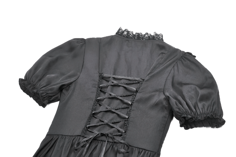 Close-up of the back of a black satin Gothic dress featuring lace-up detail and ruffled sleeves.