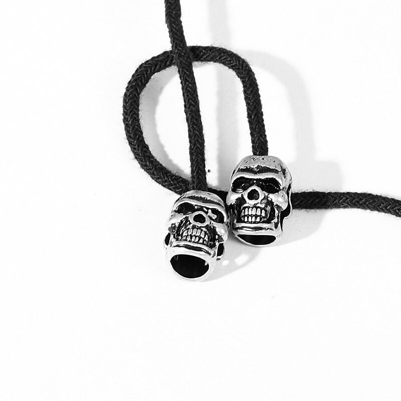 Skull beads on a black cord, perfect for gothic accessories and unique jewelry designs.