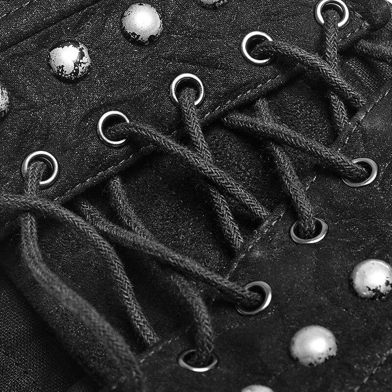 Close-up of a black Victorian-inspired studded corset with metallic rivets and lace detailing.