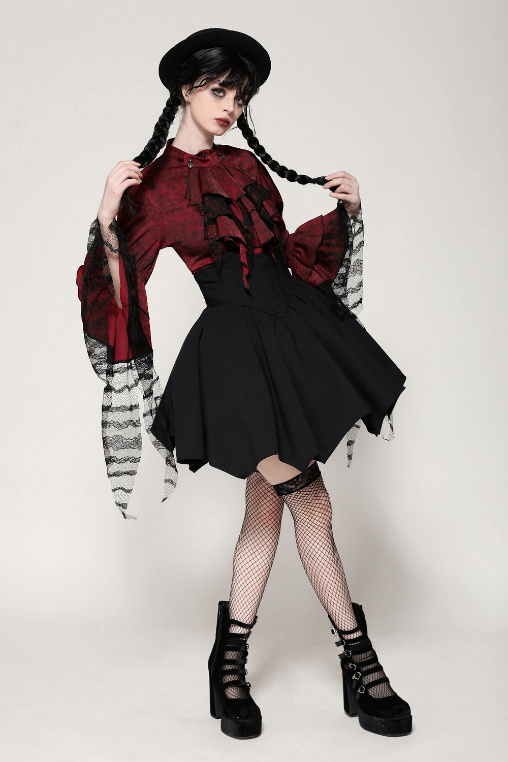 Model showcasing a Victorian-inspired wine red lace and ruffle blouse with a black skirt and fishnet stockings.