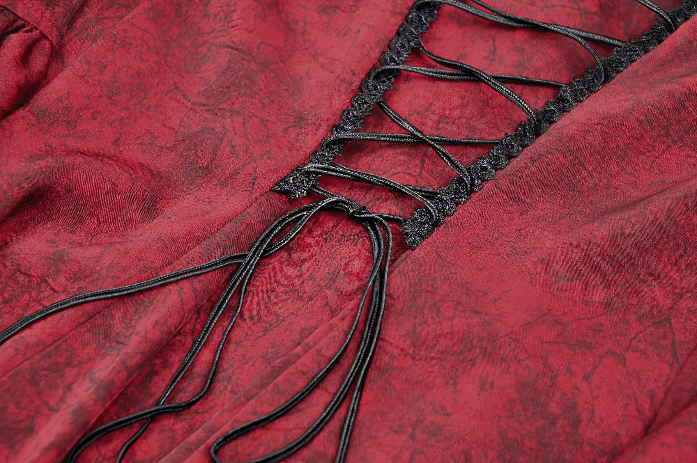 Close-up of the corset-style lacing and black lace detailing on a wine red Victorian-inspired blouse.