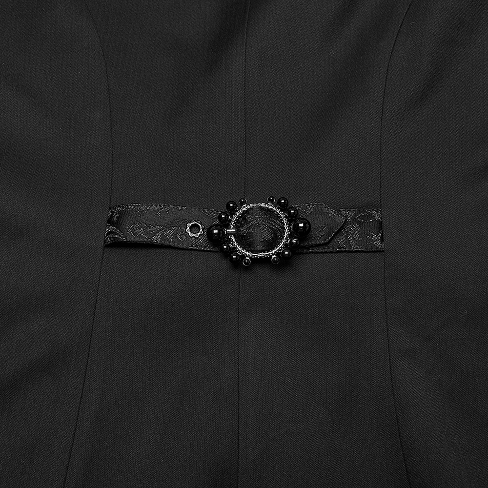 Elegant black fabric detail featuring a decorative brooch and lace waistband, perfect for gothic-inspired fashion.