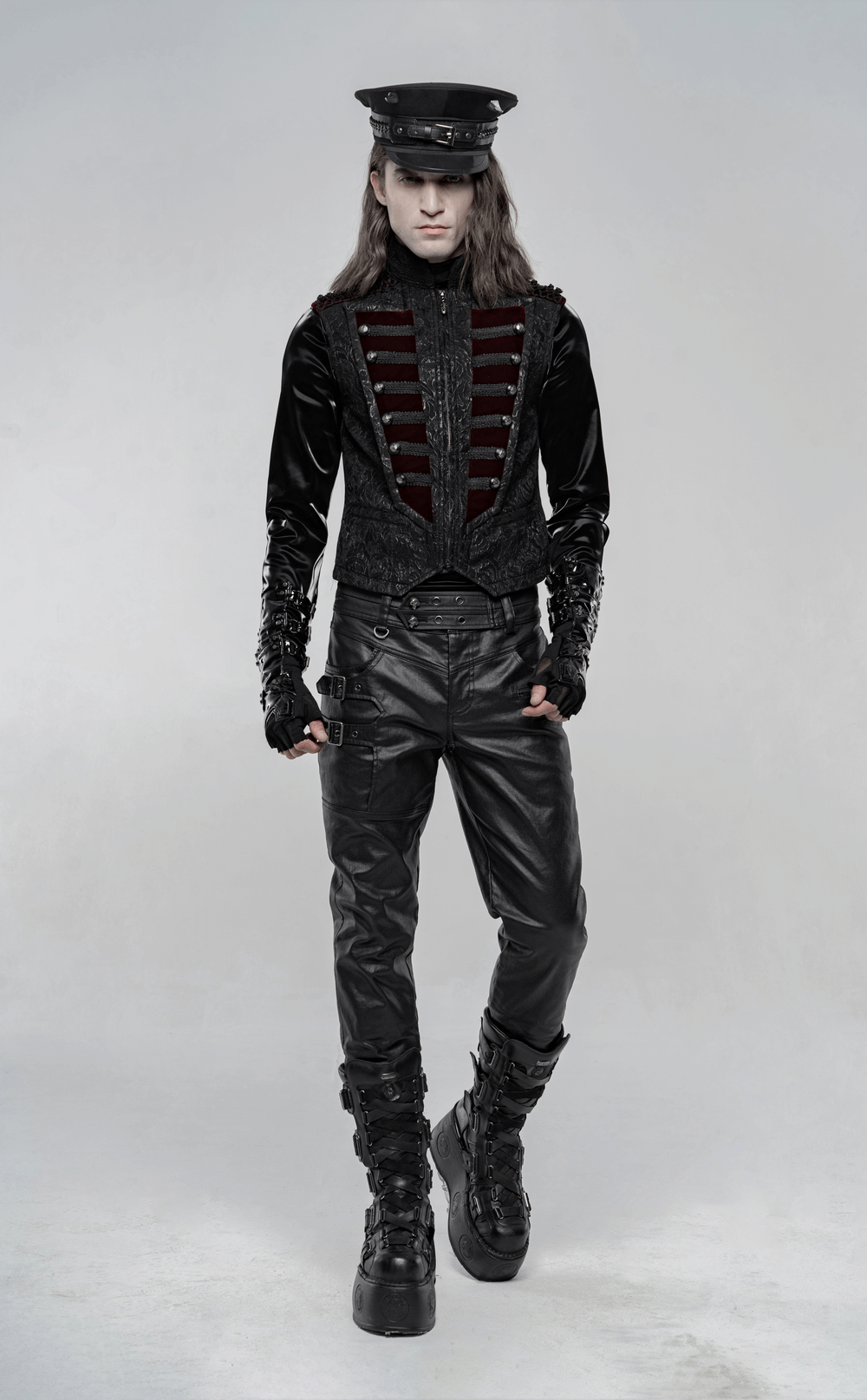 Gothic-inspired model in black velvet waistcoat and leather pants, showcasing edgy fashion elegance.