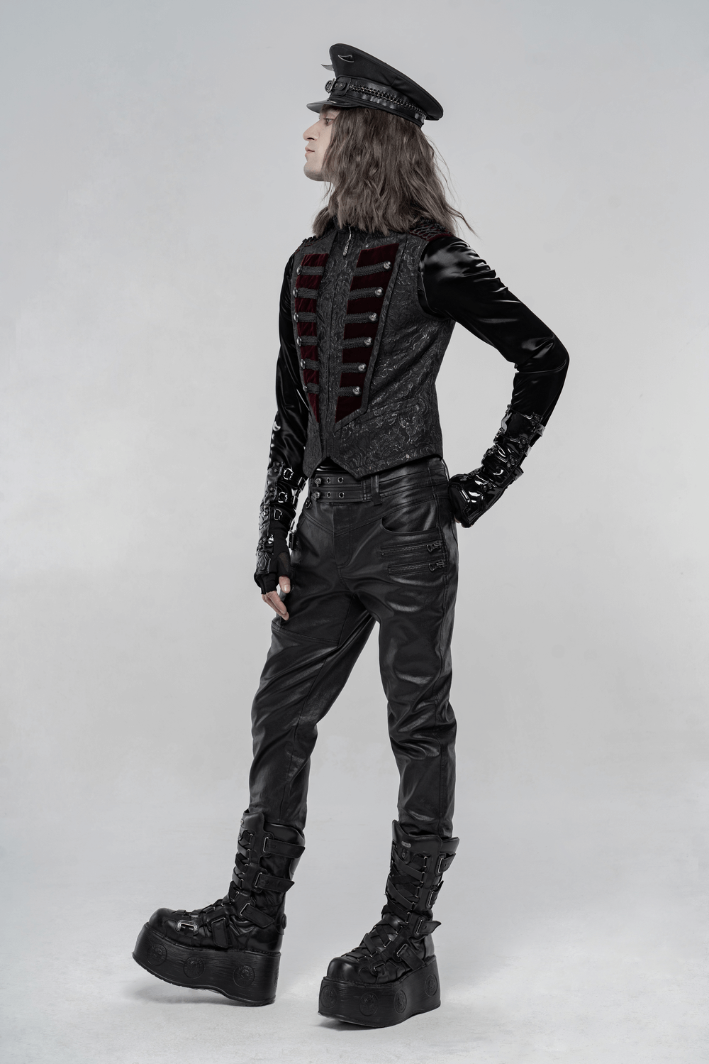 Model showcasing a vintage Gothic waistcoat with velvet detail, paired with stylish platform boots and a cap.