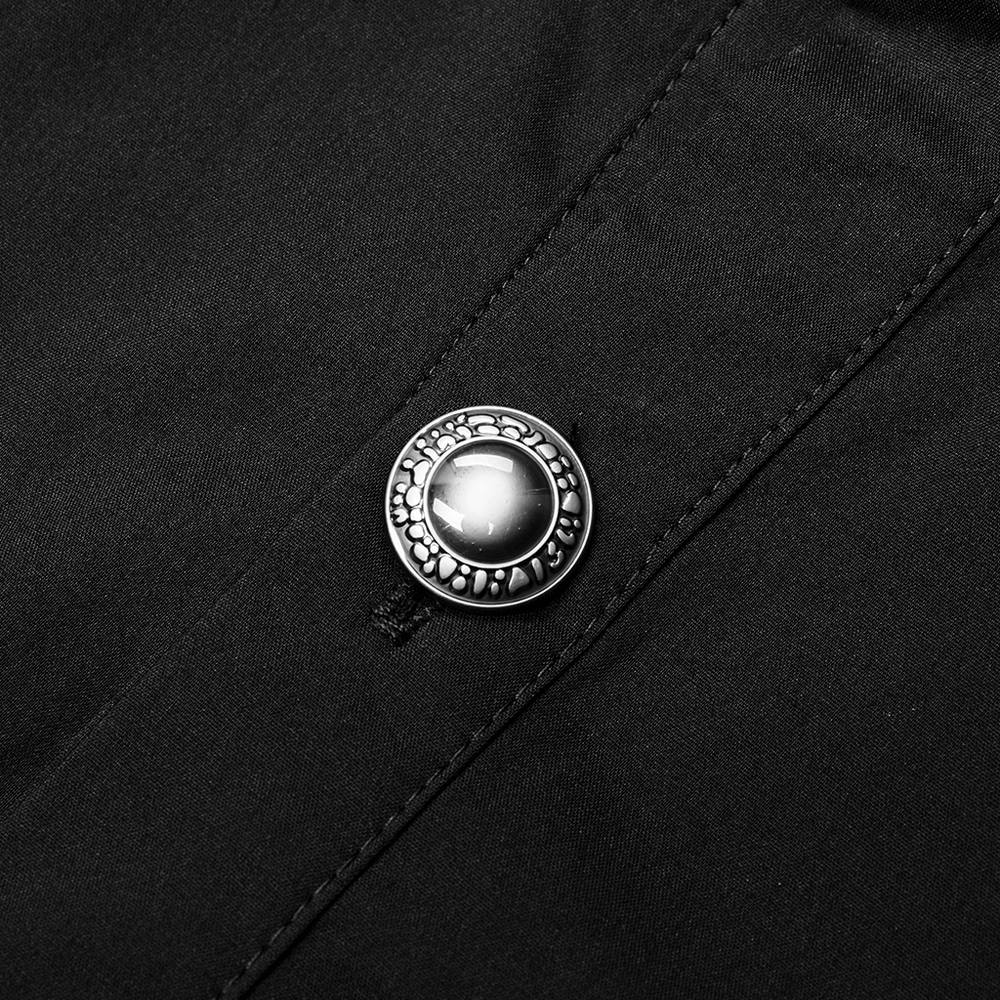 Close-up of a decorative hand-sewn button on a black gothic Victorian shirt, showcasing intricate design and texture.