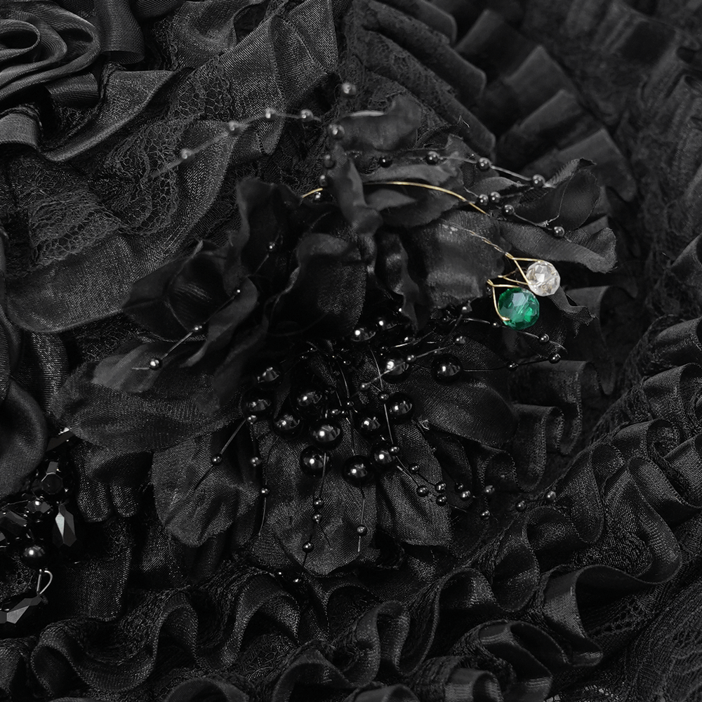 Close-up of black floral details with ruffled trim and decorative pins on a gothic Victorian lace hat.