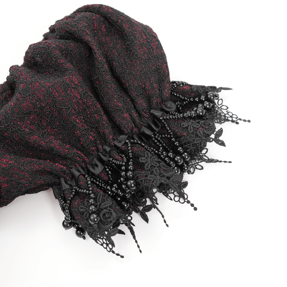 Close-up of black and burgundy lace fabric with beaded detail and ruffles for a Victorian-inspired dress.