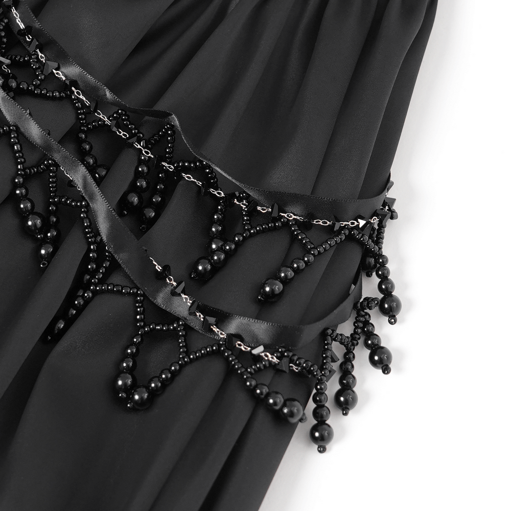 Close-up of intricate black beaded detail and lace trim on a gothic dress, showcasing elegance and dark romance.