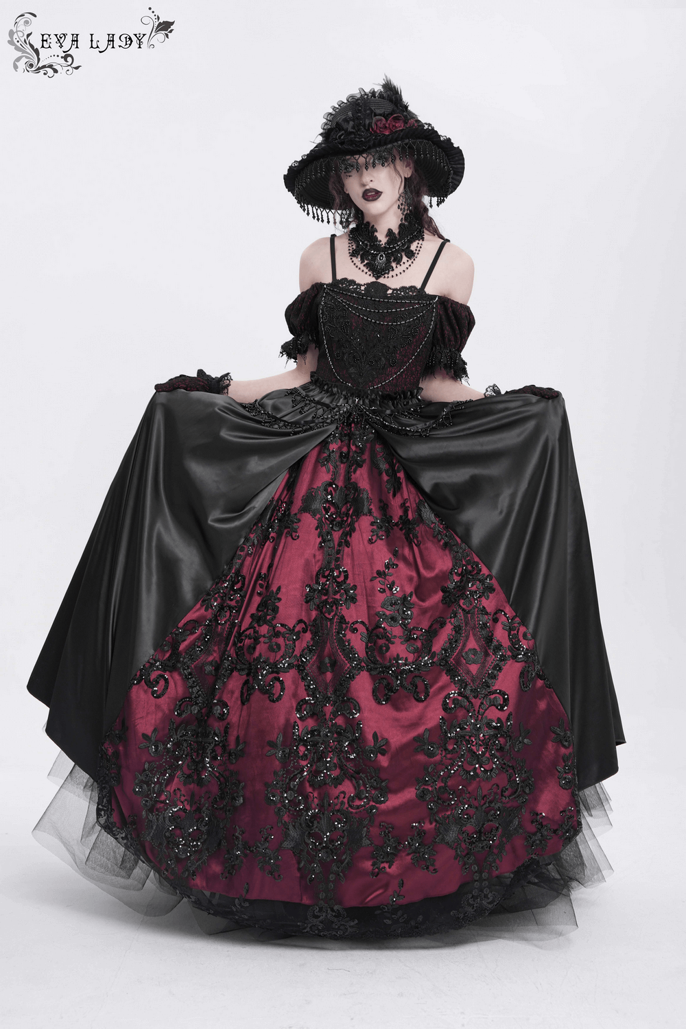 Elegant Victorian lace-up dress in black and burgundy with beaded detail, ruffles, and a dramatic black hat.