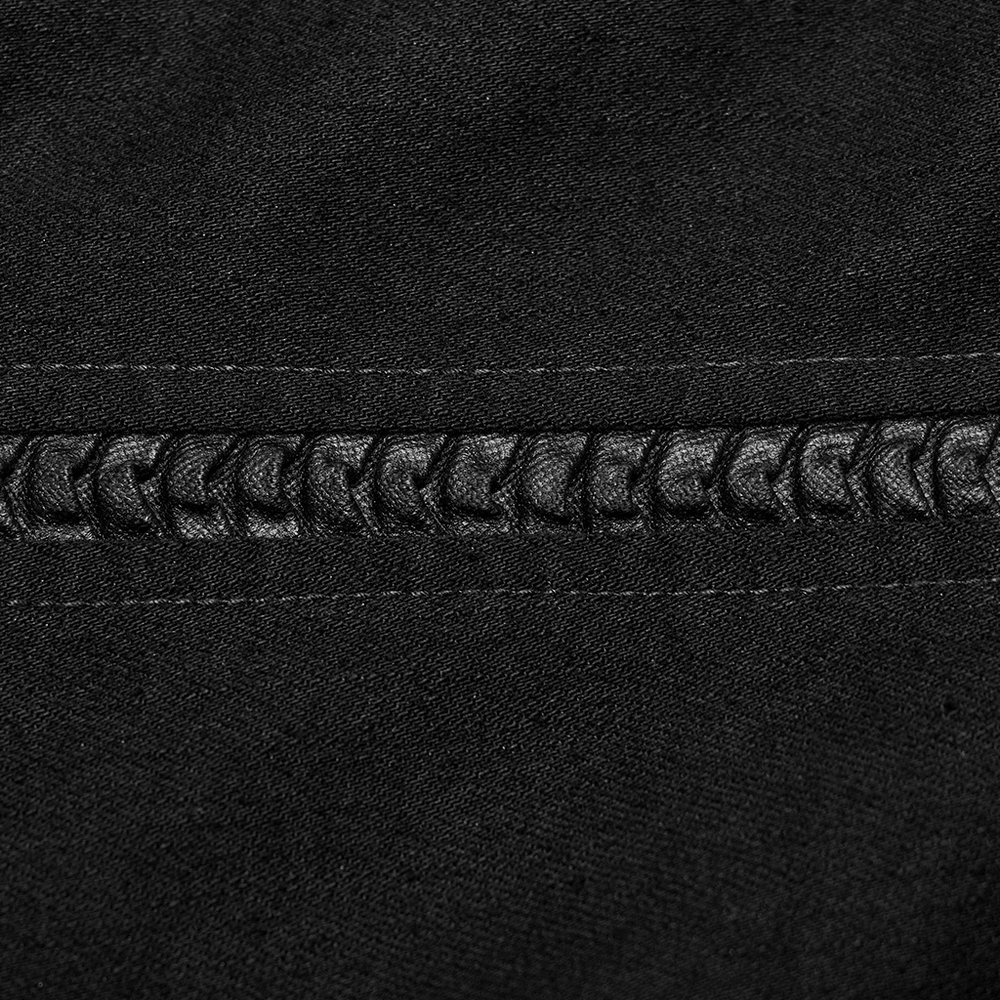 Close-up of black denim with decorative stitched lace detailing for a gothic punk style.