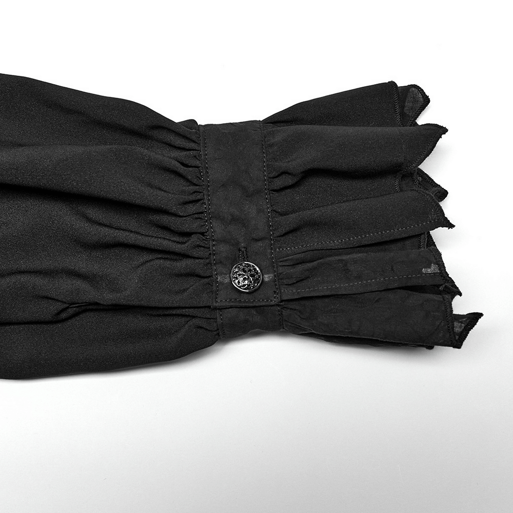 Close-up of the ruffled cuff of a black Gothic Victorian shirt with a decorative metal button.