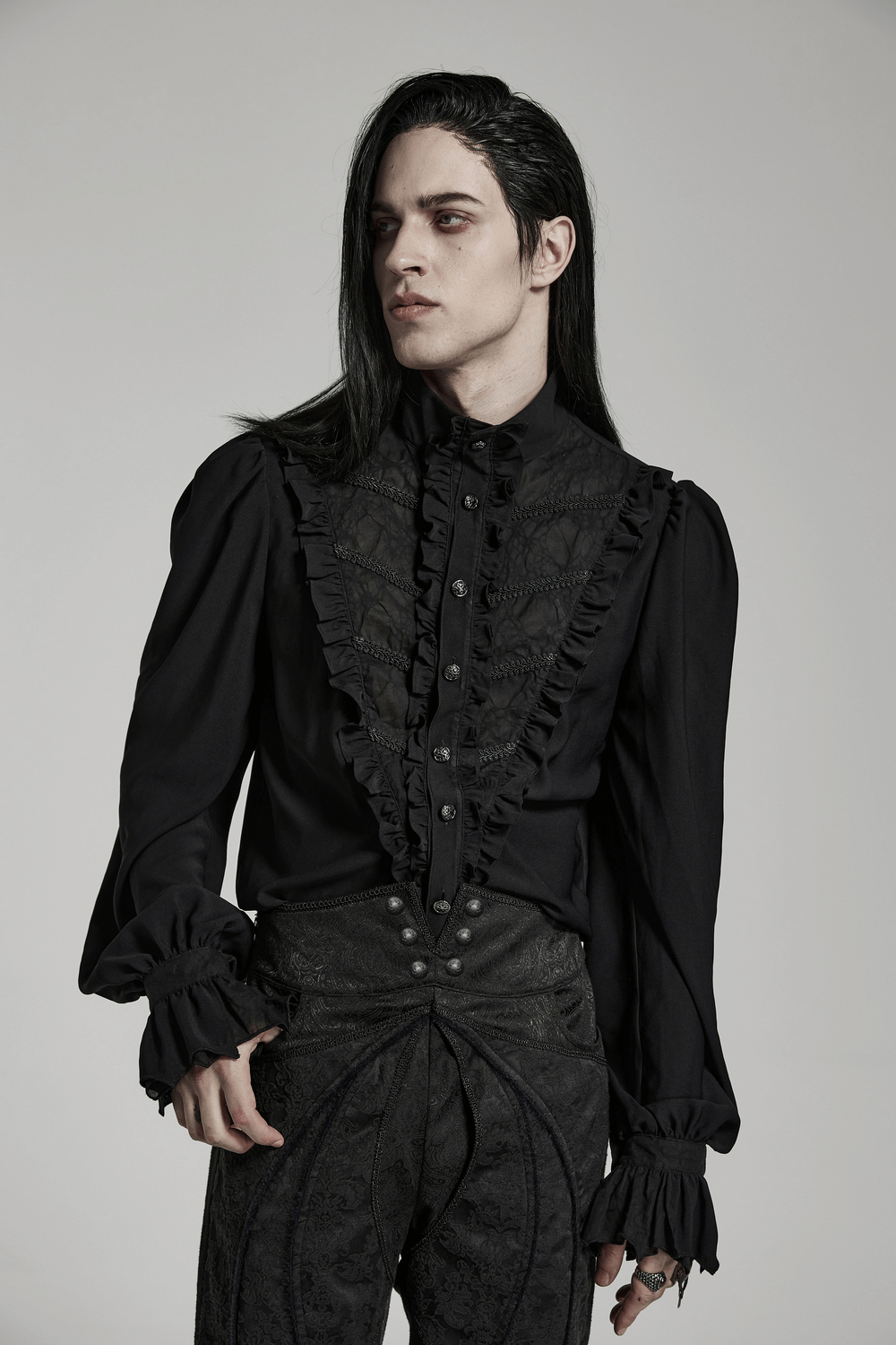 Victorian ruffle black gothic shirt worn by model with long hair, showcasing elegant puff sleeves and ruffled detailing.