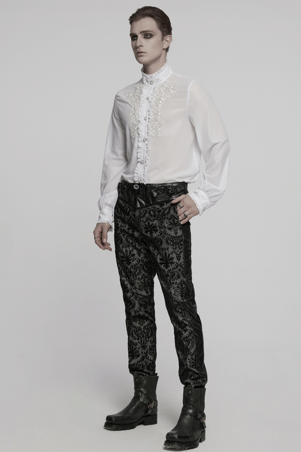 Elegant white Victorian ruffle shirt with gem buttons and intricate embroidery, paired with stylish dark pants.
