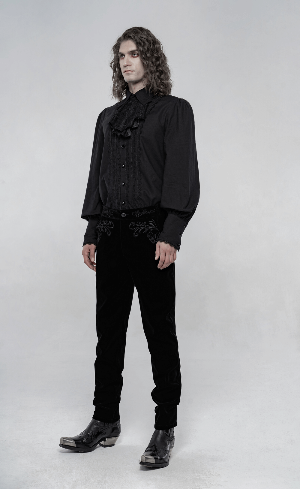 Victorian style black velvet gothic trousers with intricate embroidery, paired with a black button-up shirt.
