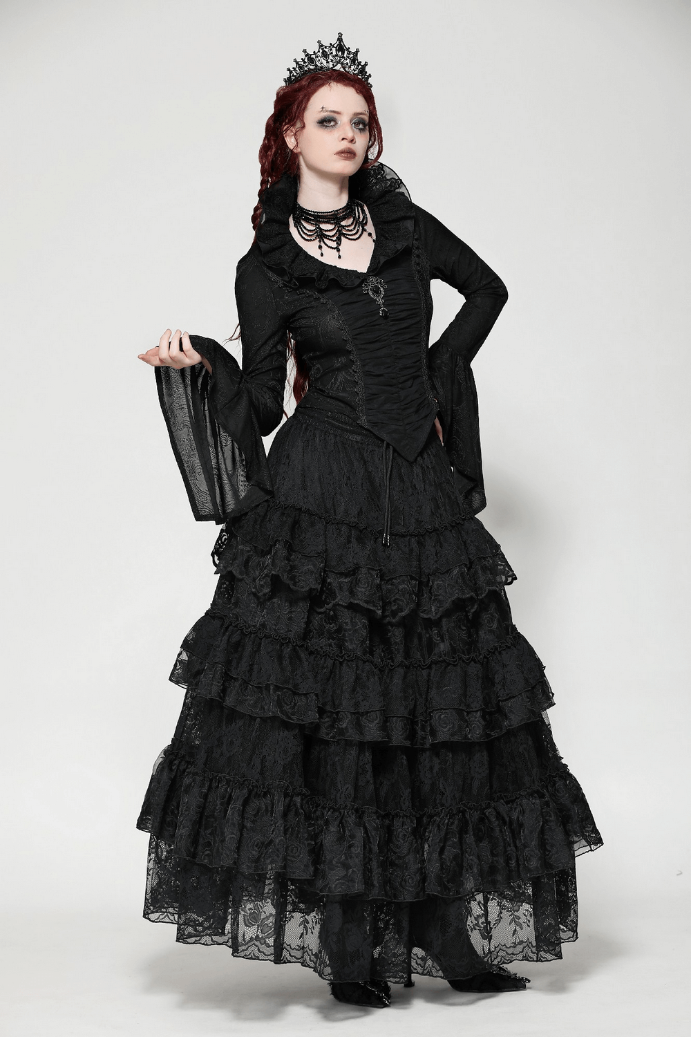 Elegant woman in a gothic black Victorian top with ruffled collar and layered lace skirt, showcasing gothic elegance and style.