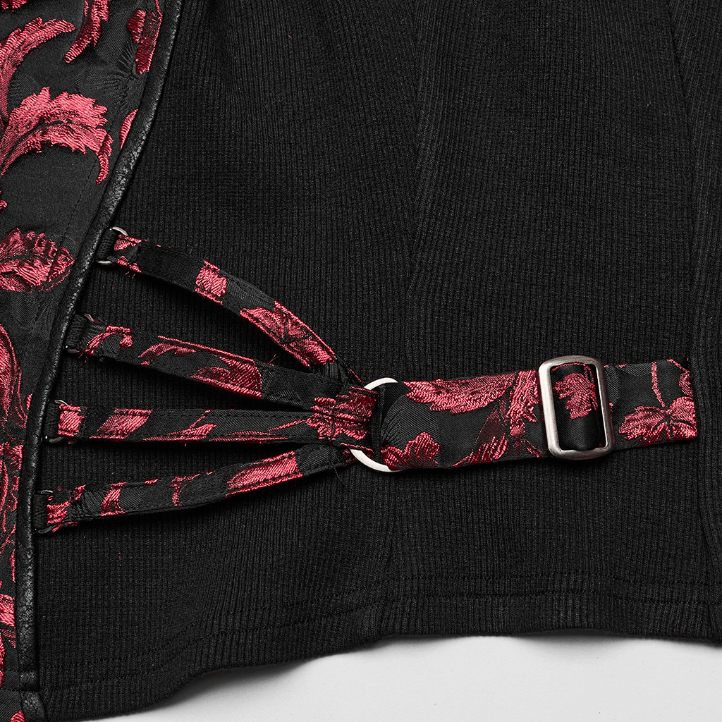 Close-up of Victorian women's steampunk waistcoat featuring red embroidery and decorative black straps.