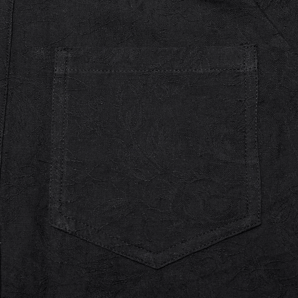 Close-up of the patch pocket on a vintage black gothic shirt for men.