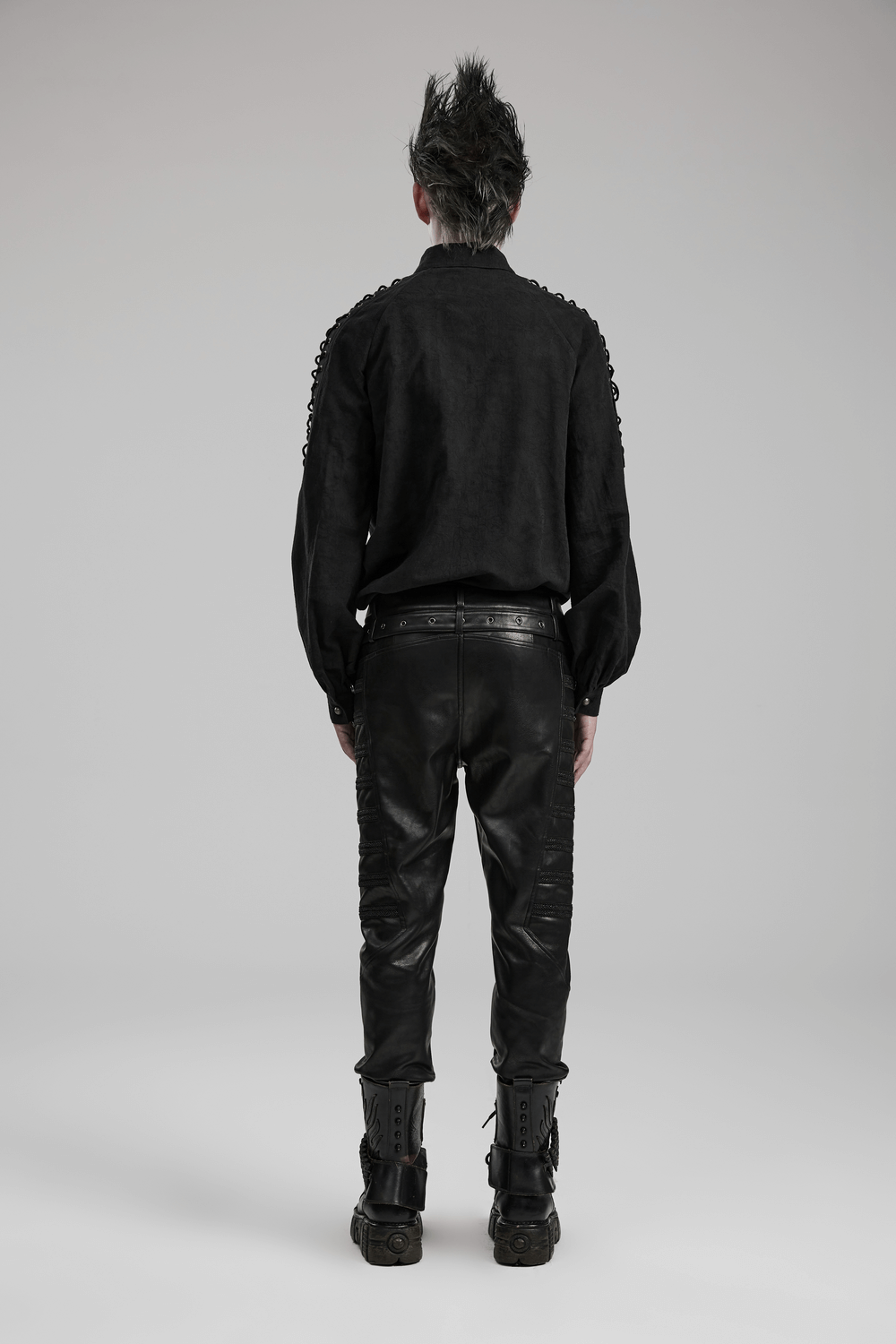 Back view of a man in a vintage black lace-up gothic shirt and black leather pants, showcasing a stylish gothic look.
