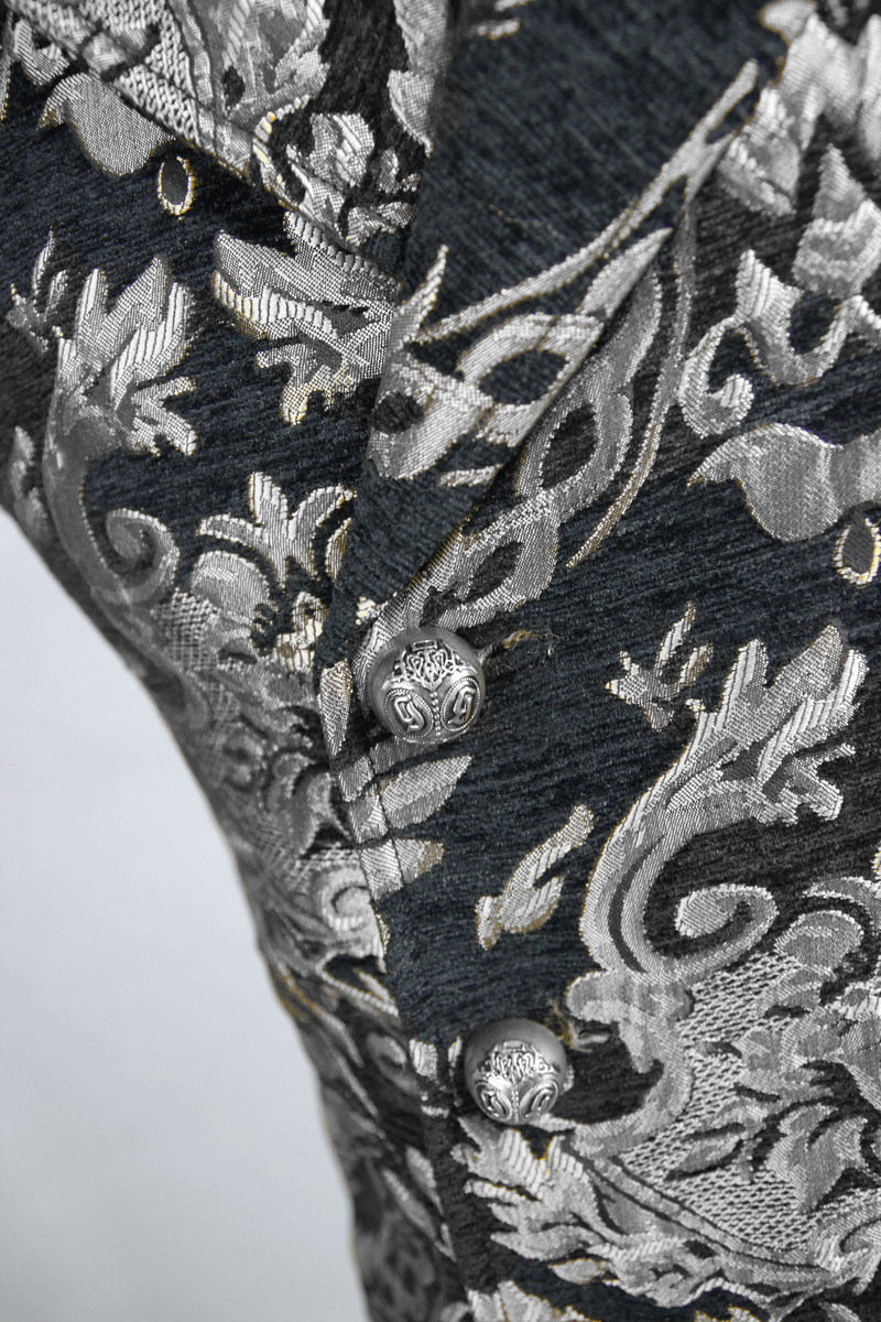 Close-up of vintage black waistcoat featuring silver filigree design and ornate buttons for men.