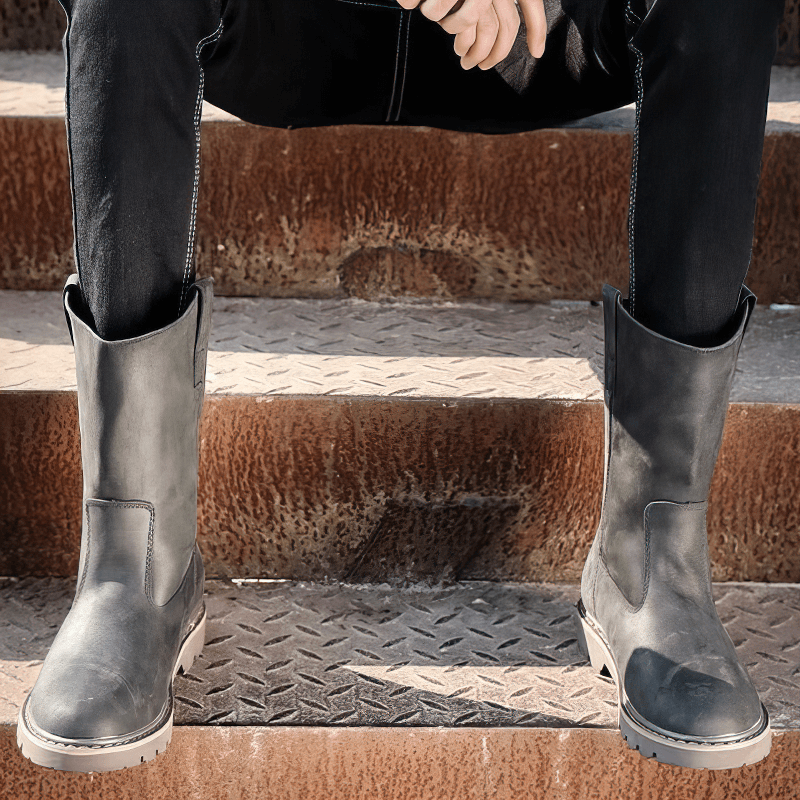 Vintage buckle boots on a person sitting on metal steps, showcasing casual rock style in genuine leather.