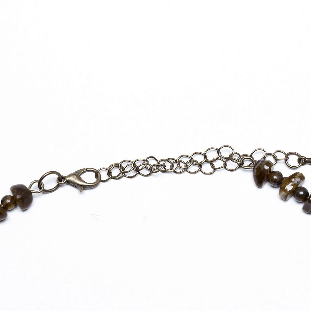 Close-up of vintage butterfly necklace clasp showing natural stones and intricate lace details.