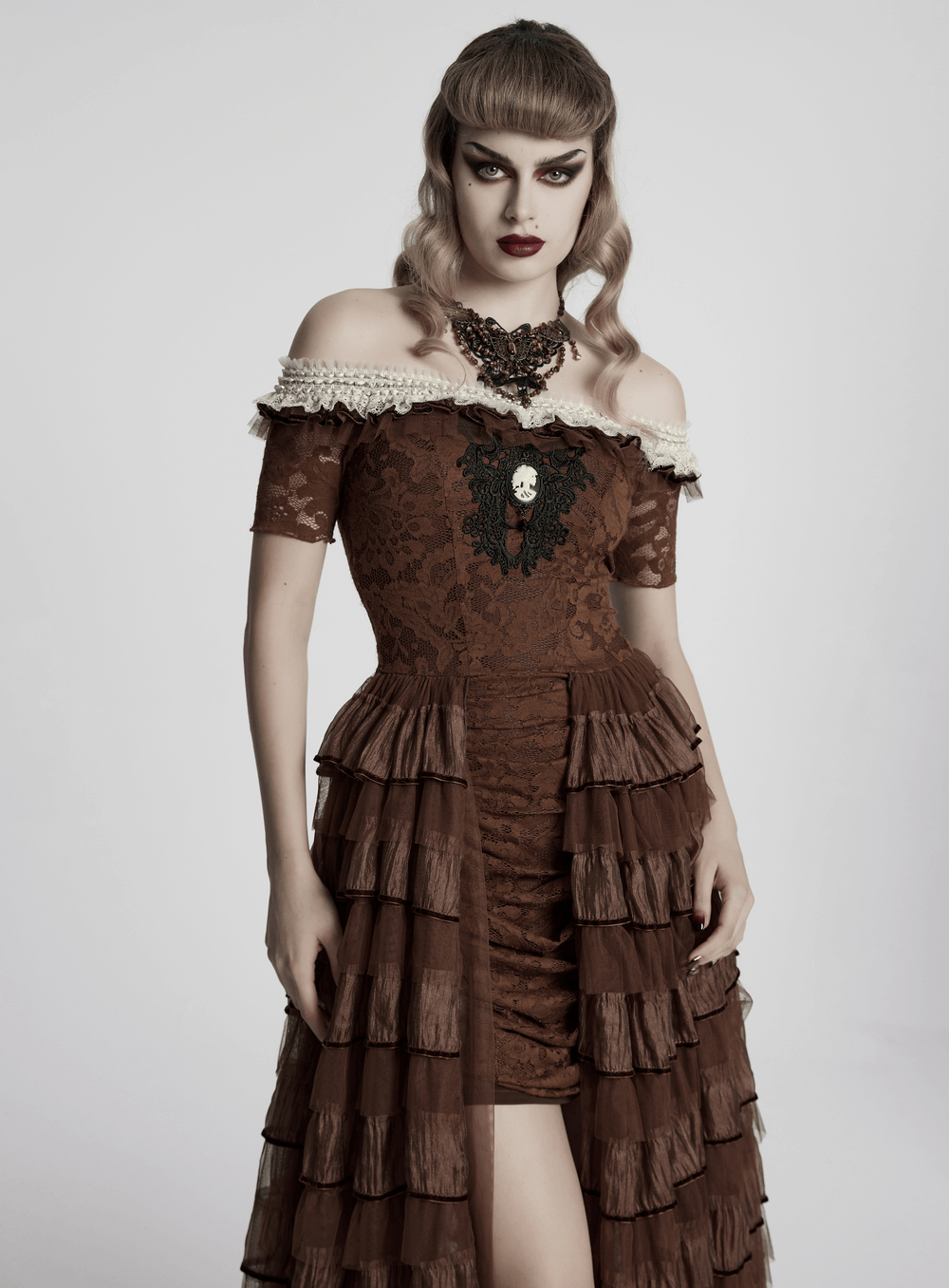 Model showcasing a vintage lace dress with ruffles and off-shoulder design, adorned with a striking butterfly necklace.