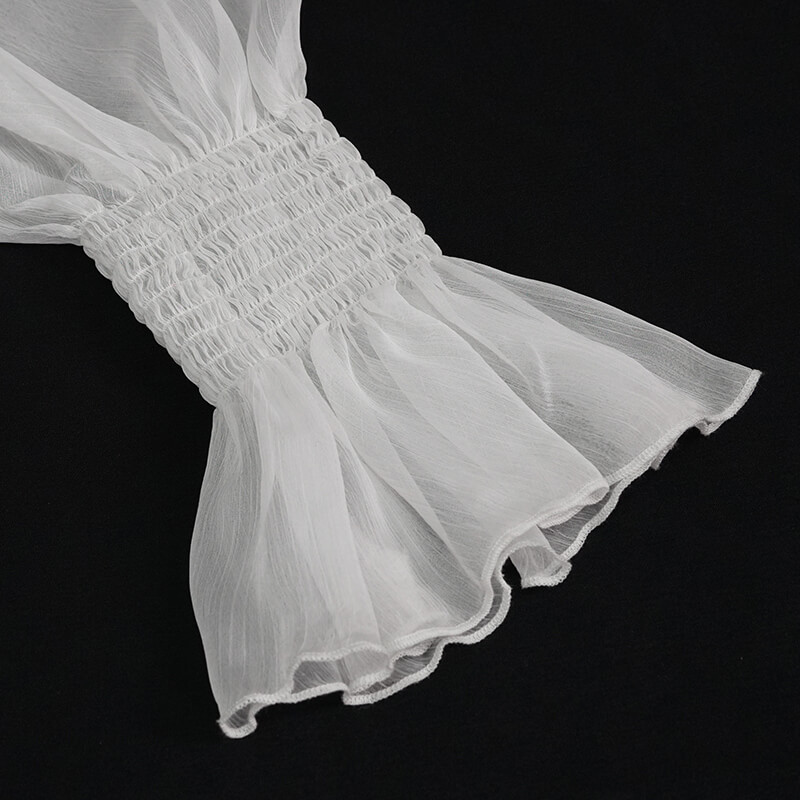 Close-up of the vintage chiffon petal sleeve of a women's blouse, featuring delicate smocking and flowing design.