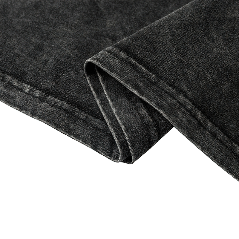 Close-up of the folded edge of a vintage black cotton long sleeve t-shirt, showcasing soft fabric and neat stitching.