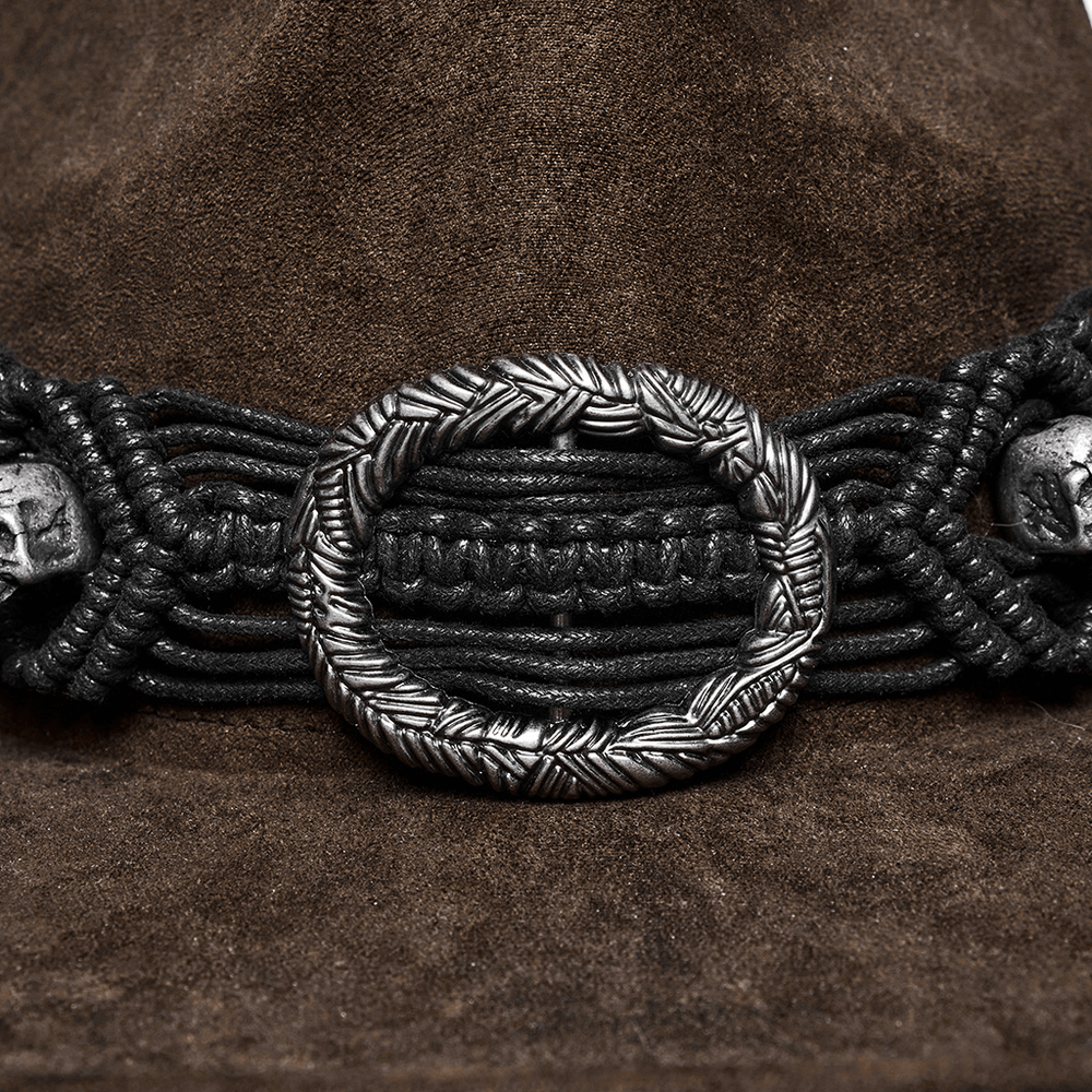 Vintage dark cowboy hat close-up showing intricate woven band with silver skull accents and bold conical style.