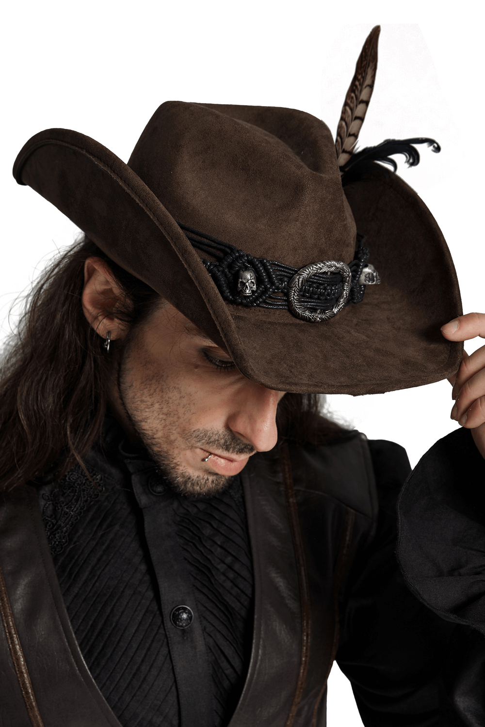 Man wearing vintage dark cowboy hat with feathers and fringe, showcasing gothic punk style.