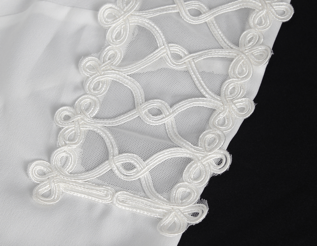 Close-up of intricate white embroidery design on a fabric, showcasing delicate loops and knots.