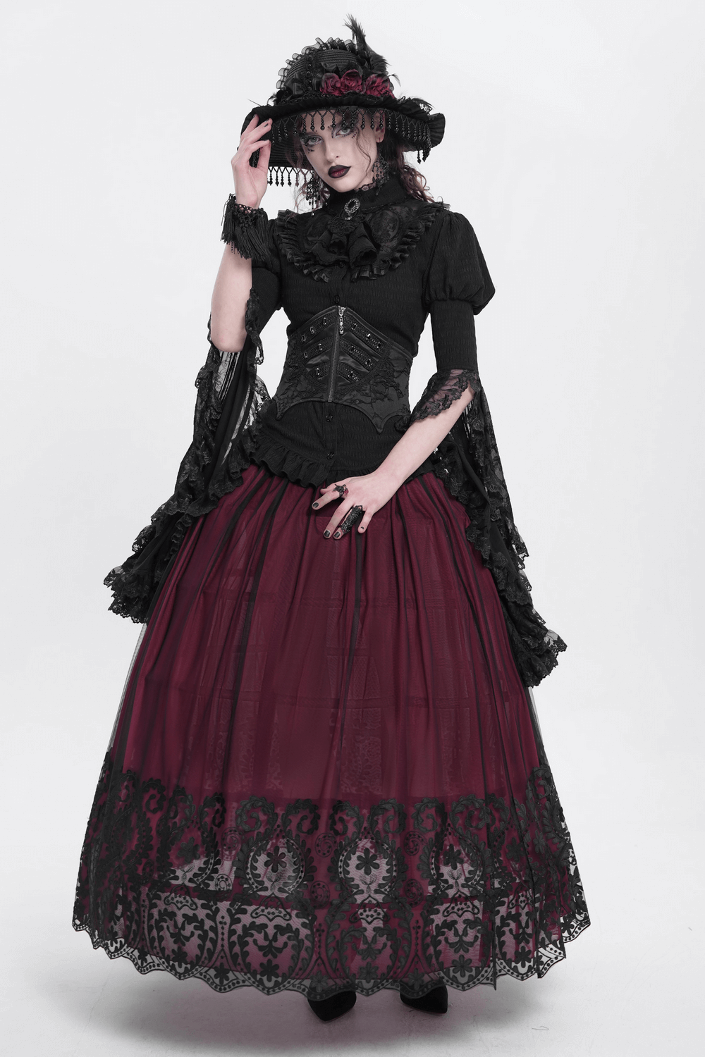Model in vintage gothic outfit showcasing a wine red mesh maxi skirt with intricate black embroidery and elegant hat.