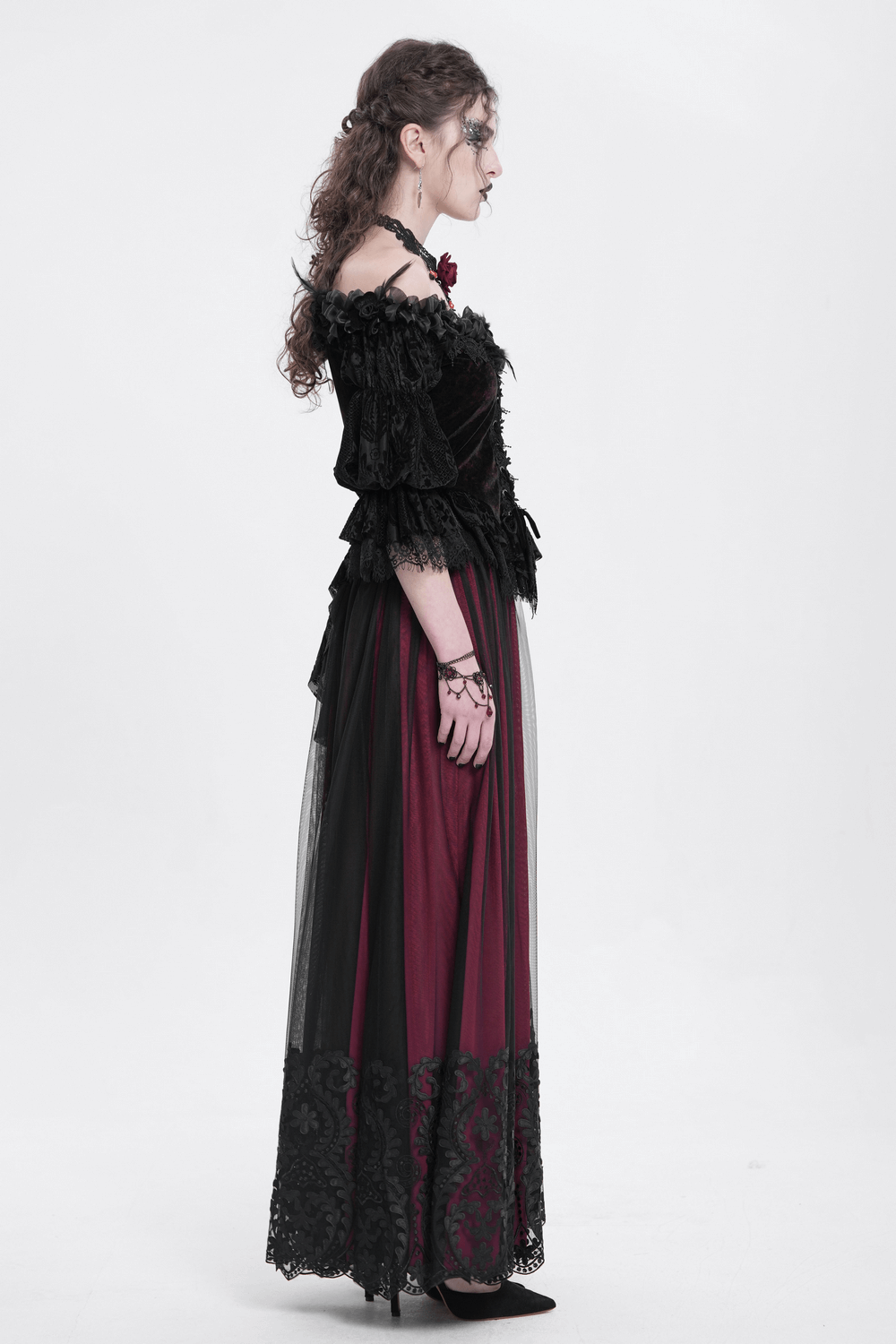 Vintage gothic model in a wine red mesh maxi skirt with black embroidery and an elegant off-shoulder top.