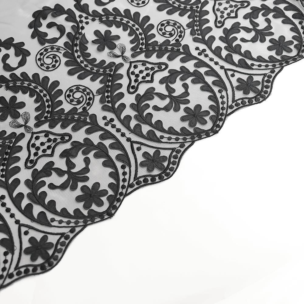 Close-up of vintage black embroidered mesh with intricate floral patterns and scalloped edge, perfect for gothic apparel.