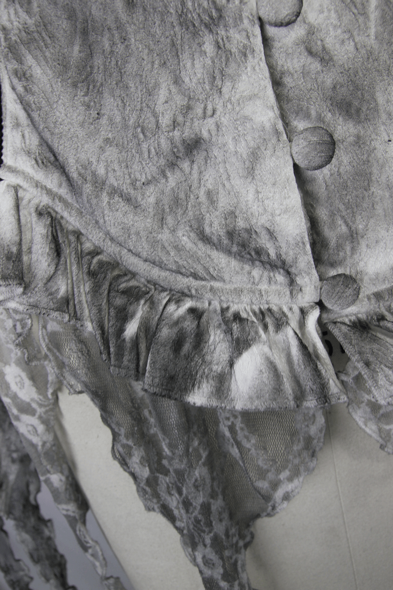 Close-up of a vintage-style gray blouse with ruffled hem and button detail, showcasing elegant gothic design.