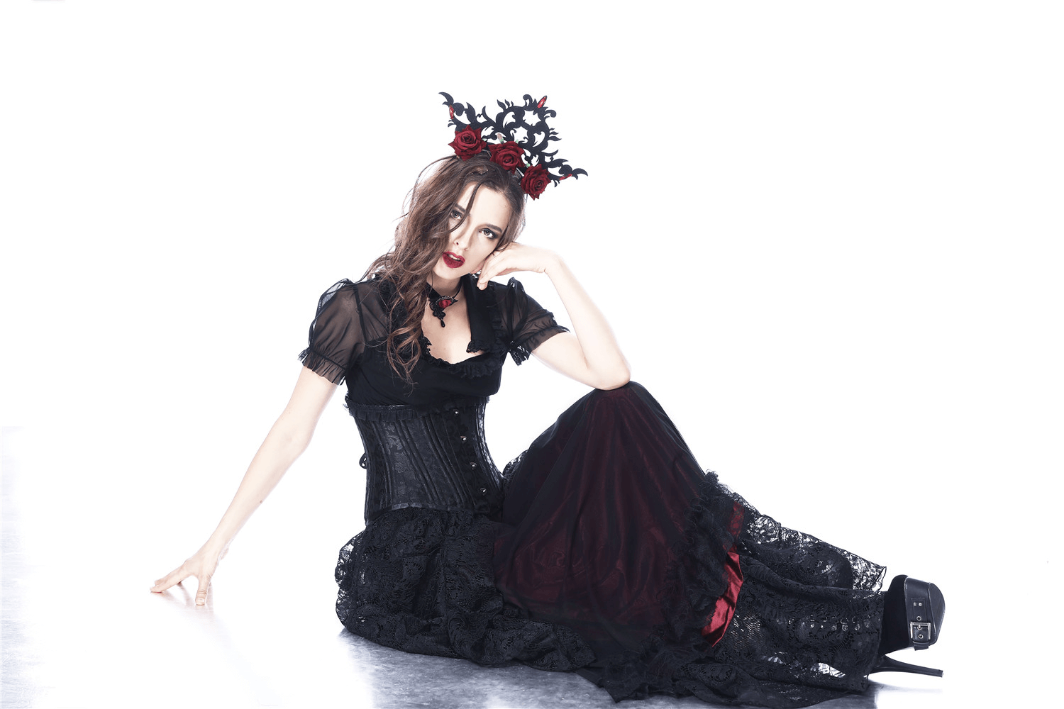 Gothic Victorian model in black lace skirt and corset, showcasing steampunk fashion with dramatic accessories.
