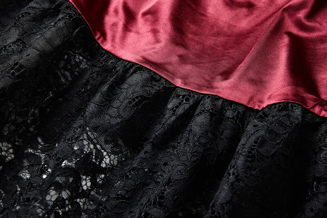 Elegant black lace maxi skirt with ruffled texture and rich maroon satin waistband, ideal for gothic and steampunk styles.