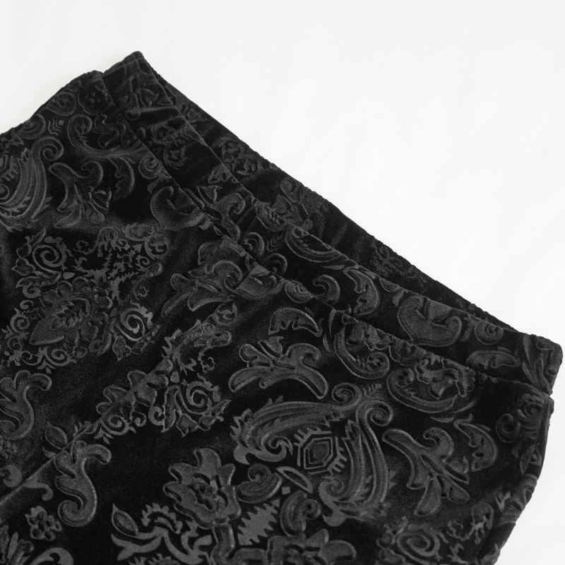 Close-up of vintage gothic floral velvet flared pants showcasing intricate black patterns.