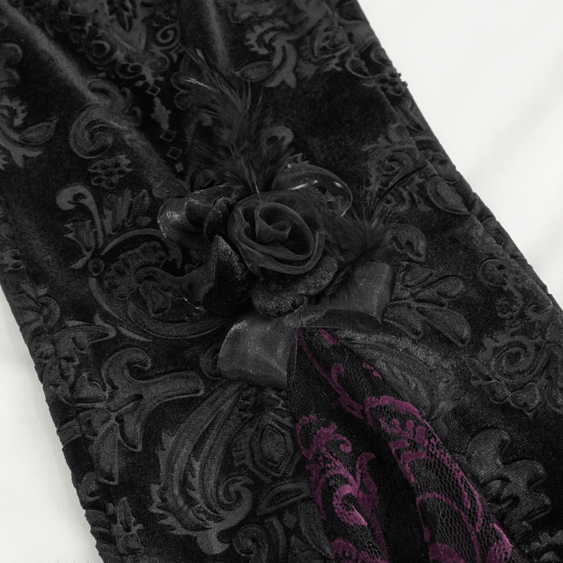Close-up of vintage gothic floral velvet fabric with a decorative rose and feather detail.