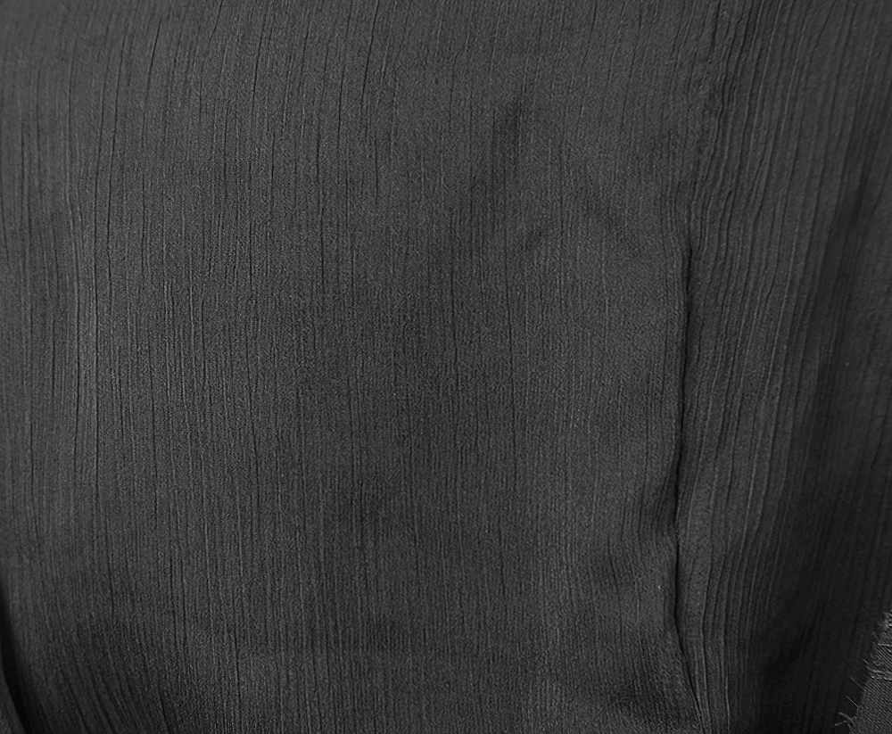 Close-up of black fabric texture of a vintage gothic hooded cape with a luxurious feel.