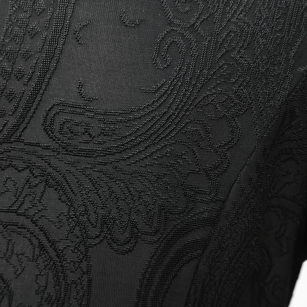 Close-up of intricate embroidery on a vintage gothic cape, showcasing elegant black patterns and textures.