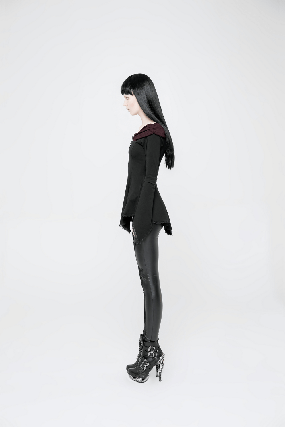 Side view of a model wearing a Vintage Gothic Long Sleeve Top with lace trim and horn cuffs, showcasing dark elegance.