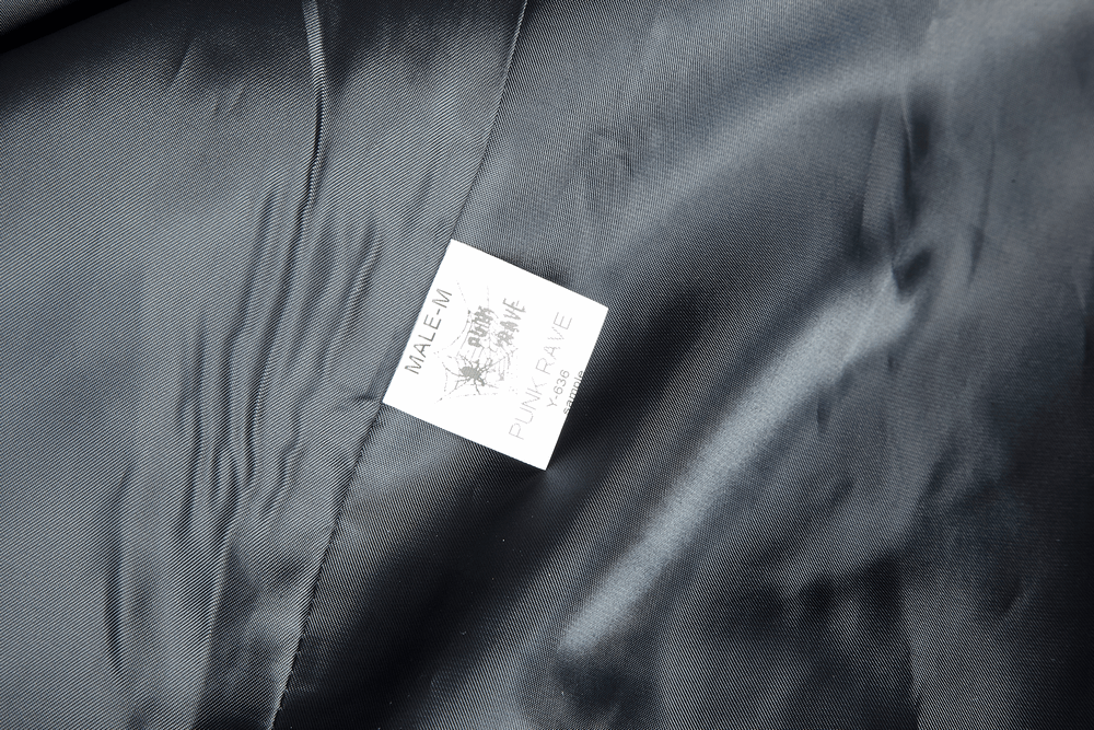 Label of a vintage gothic male velvet cloak with leather accents, showcasing brand details and fabric quality.