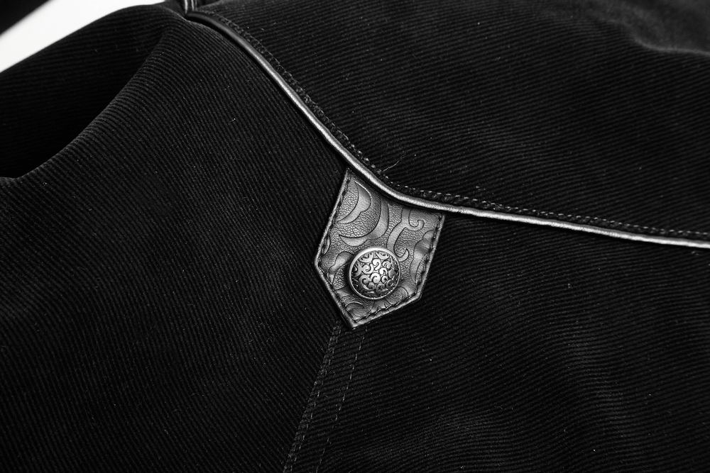 Close-up of vintage gothic velvet cloak showing ornate leather collar and decorative button detail.