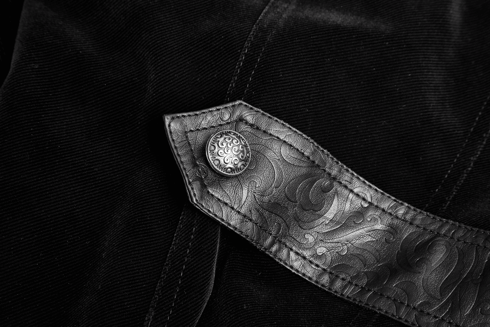 Close-up of vintage leather collar with ornate design on a velvet cloak, showcasing gothic style and elegance.