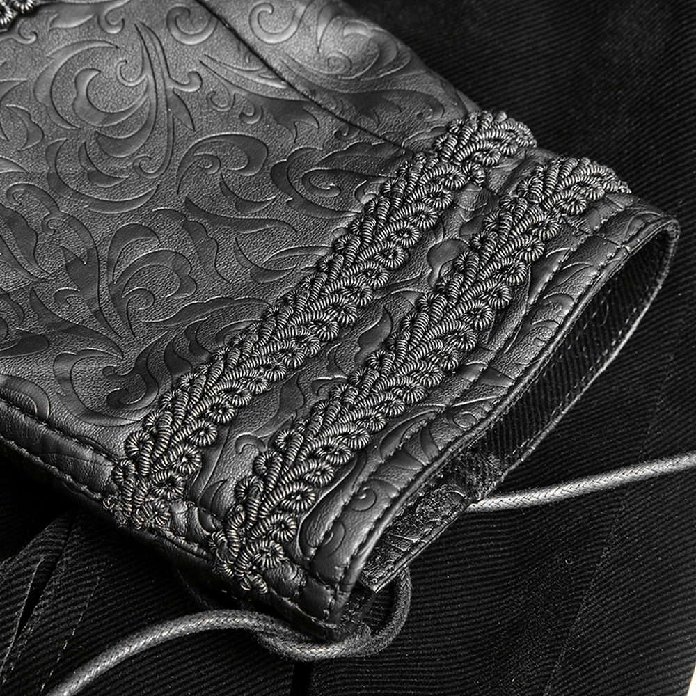 Close-up of a vintage gothic leather sleeve with intricate embossed patterns and decorative trim.
