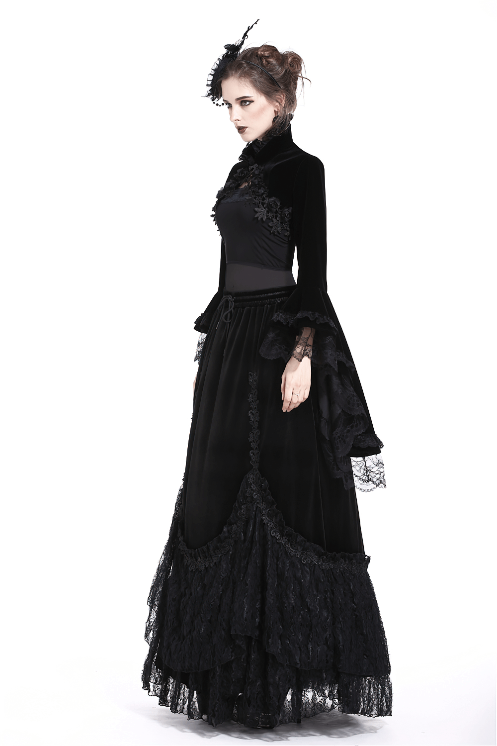 A model showcasing a vintage gothic velvet bolero with lace sleeves and a matching long black skirt, embodying Victorian elegance.